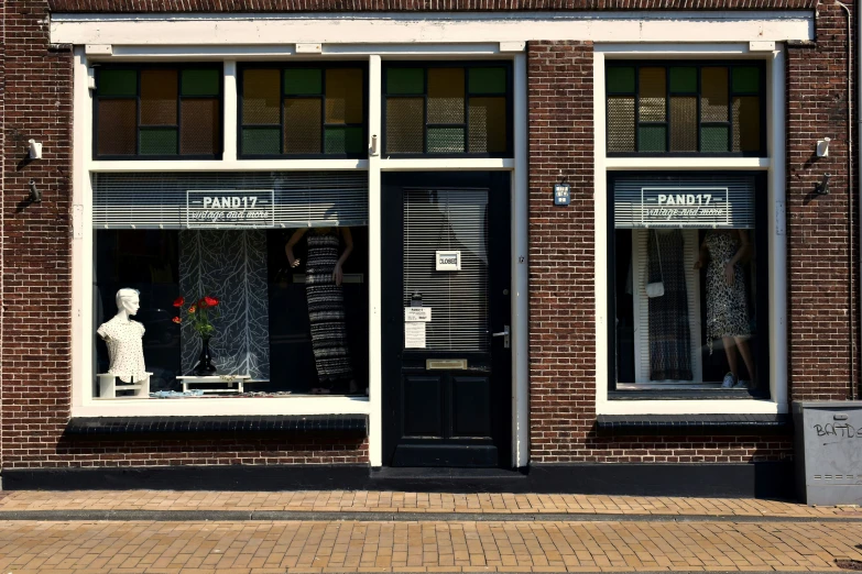 the exterior of a building showing a statue, window display, and store front