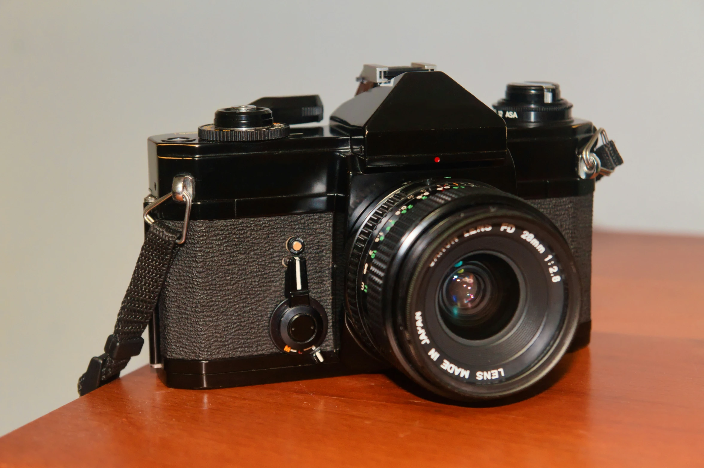 an old camera sits on a wood table