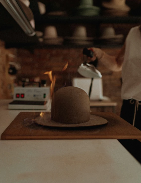 a woman preparing food in a kitchen while wearing a hat