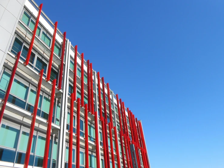 a large, red sculpture against a building's architecture