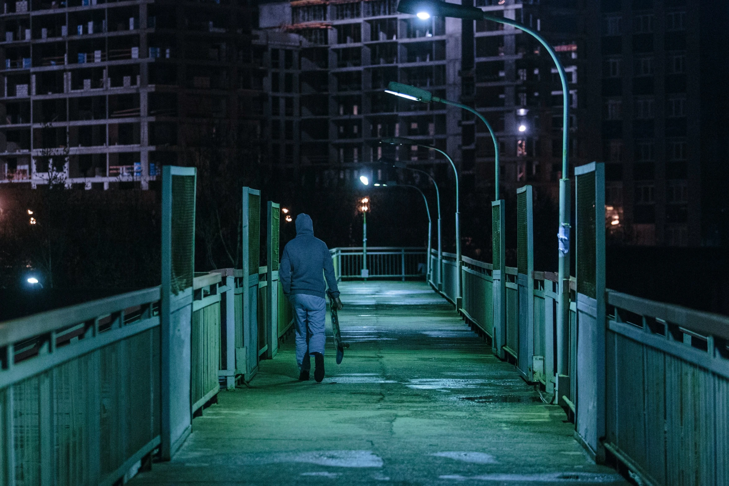 a person walking over a bridge at night