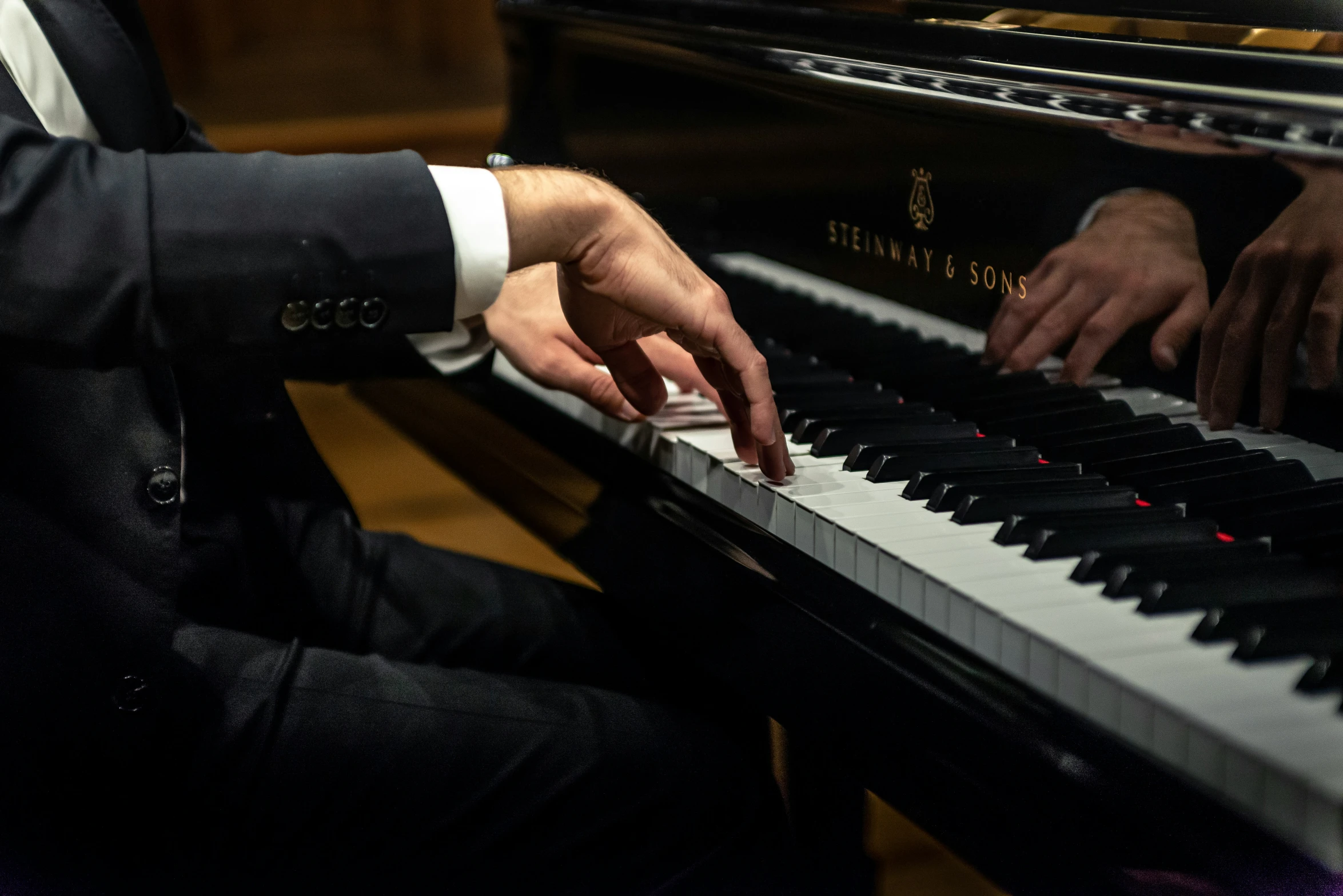 the person in the tuxedo is playing piano