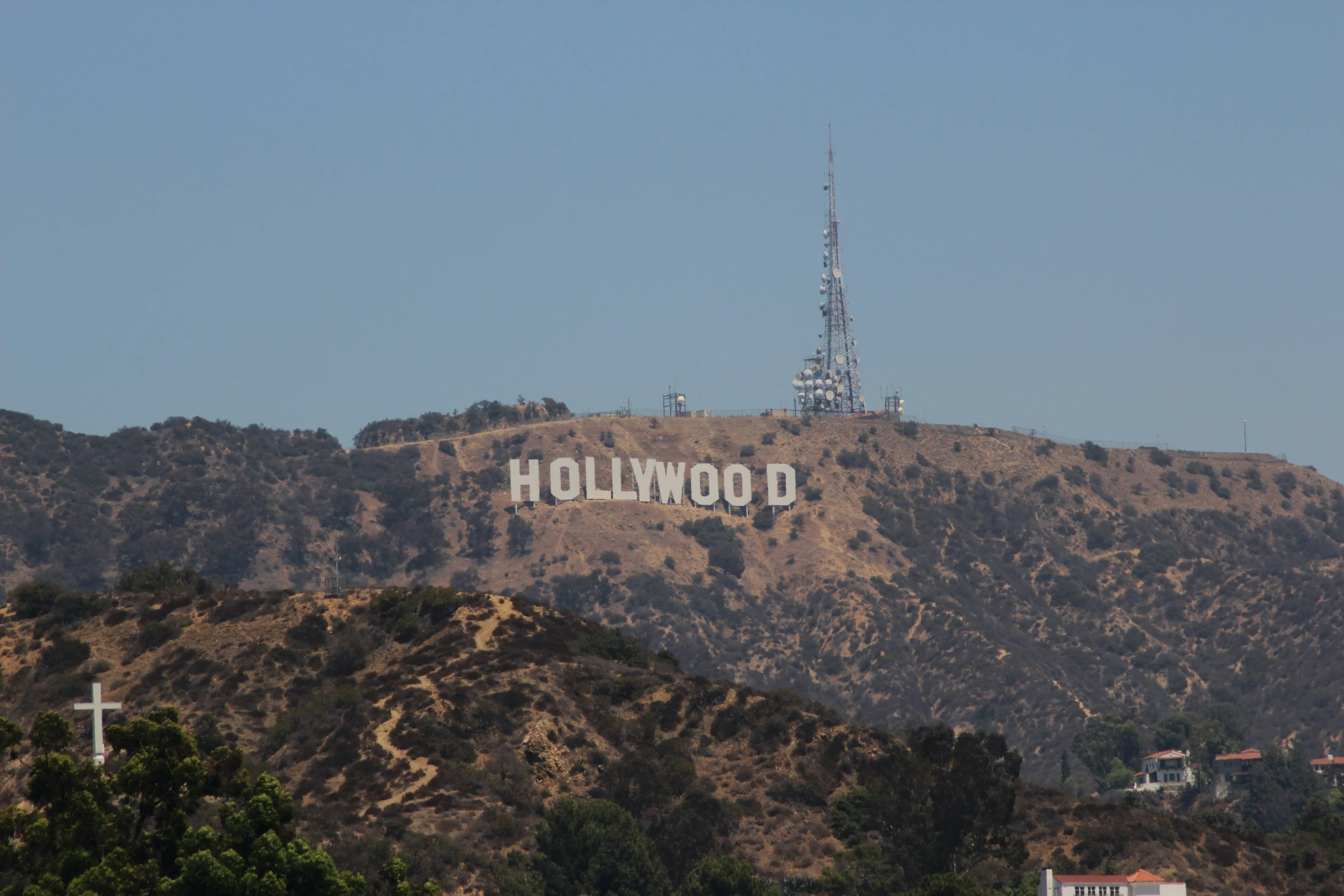 hollywood sign atop a hill behind a building