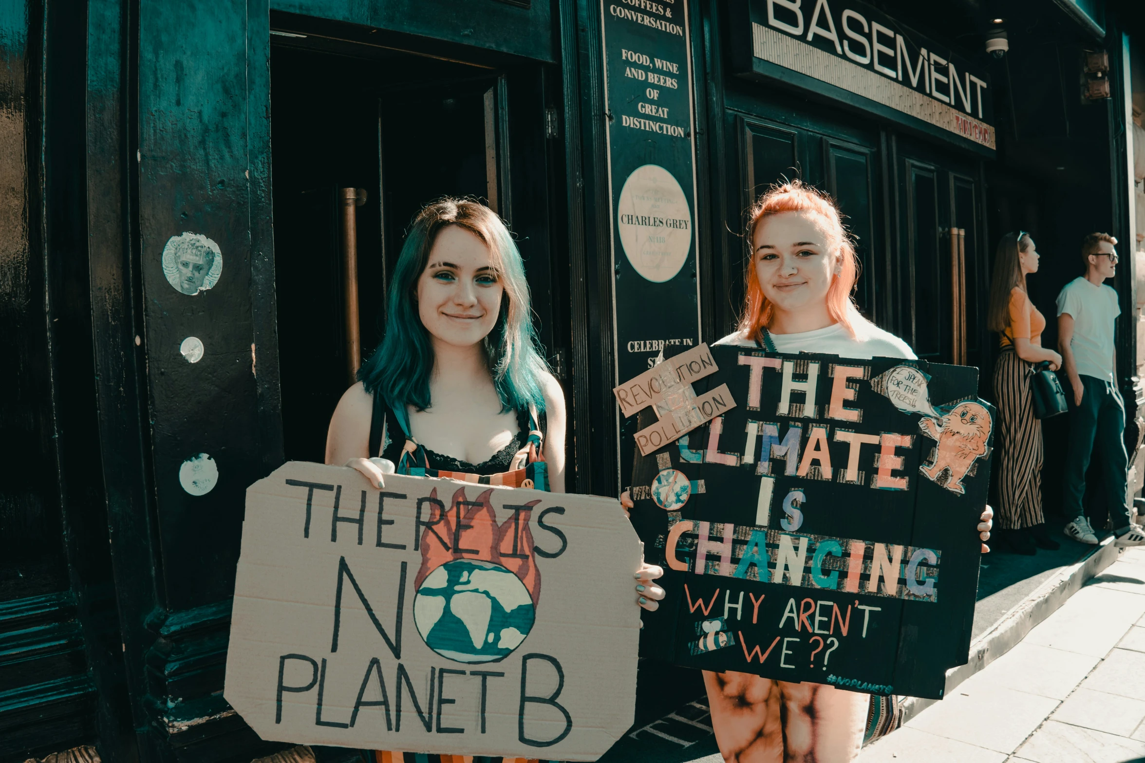 a girl is holding a protest sign next to another girl