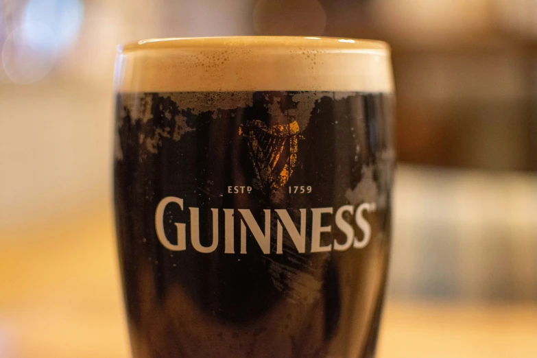 a close up view of a tall glass filled with guinness