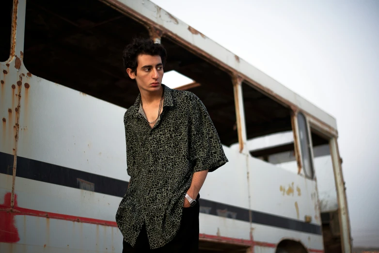 young man posing in front of a rusty train