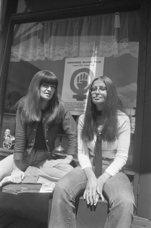 a woman sitting next to another women on a bench