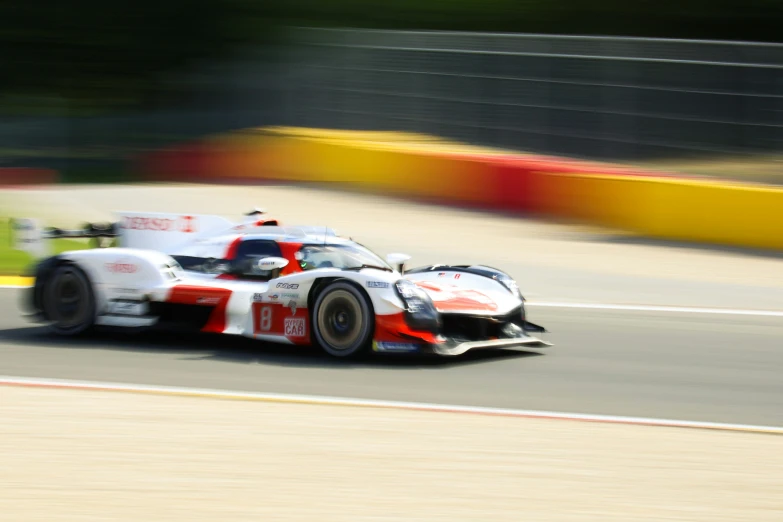 a racing car driving down the road on a race track