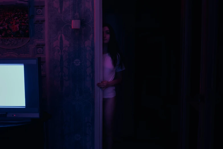 a  standing in front of a dark door