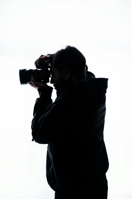 man pographing a white back ground with his camera