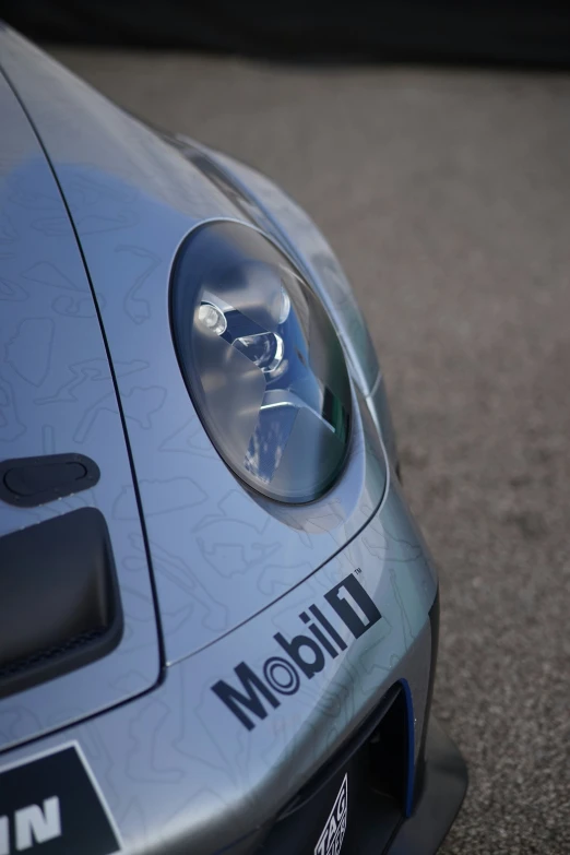 the front end of a sports car on a road