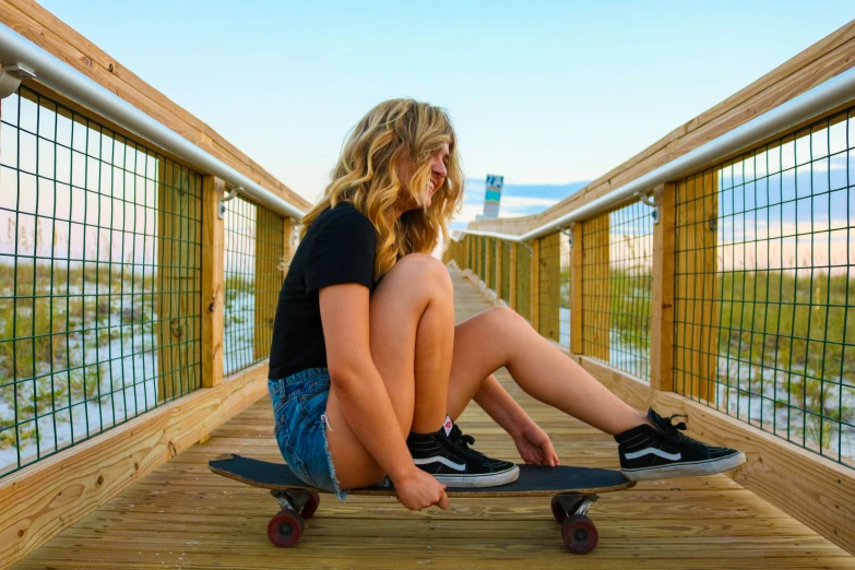 two s are sitting on skateboards on a pier