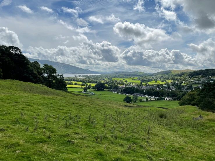 a large open field surrounded by trees and hills