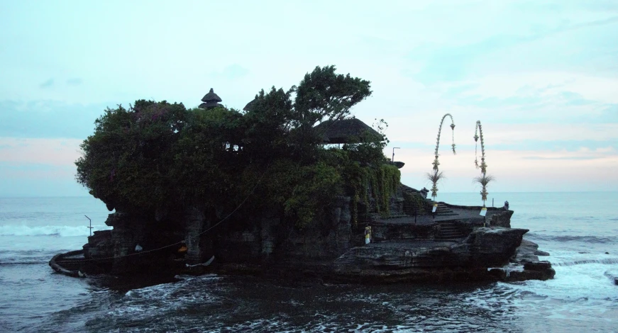 a beach with two trees on top in the middle