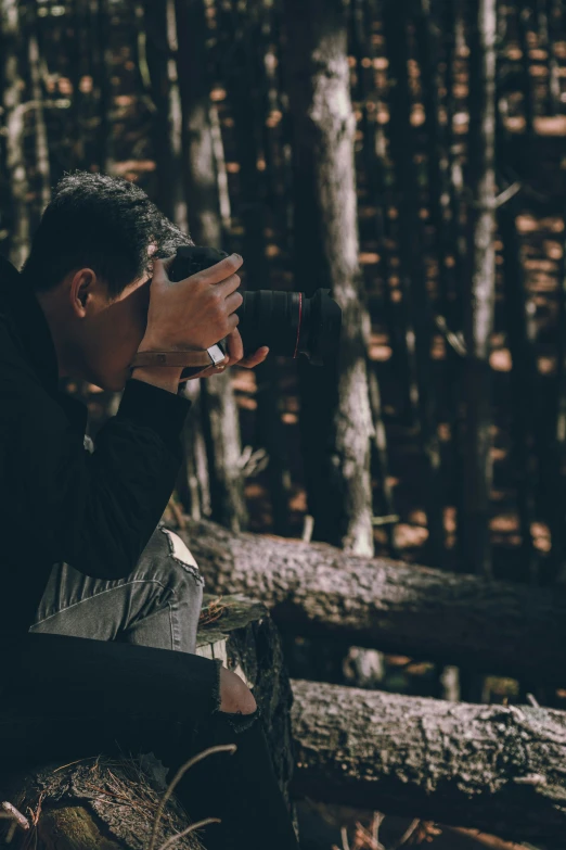 a man is holding a rifle in the forest