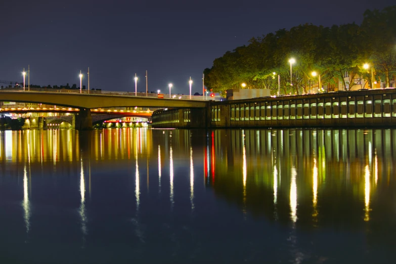 a bridge crosses over the water at night