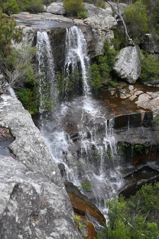 several large rocks surround a waterfall with water flowing
