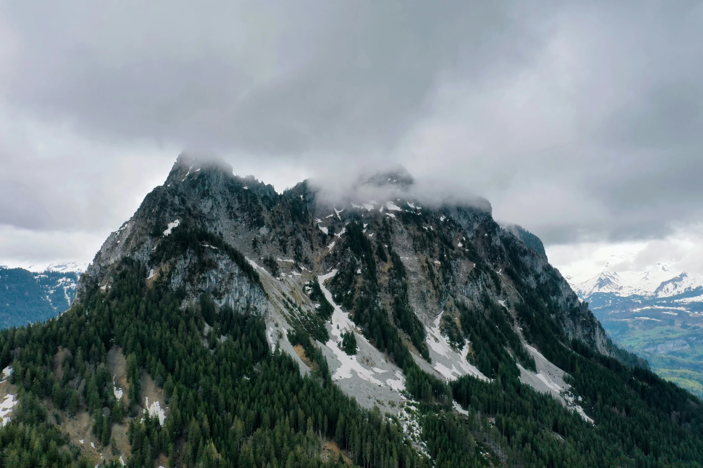 there is snow on the mountain with clouds in the sky