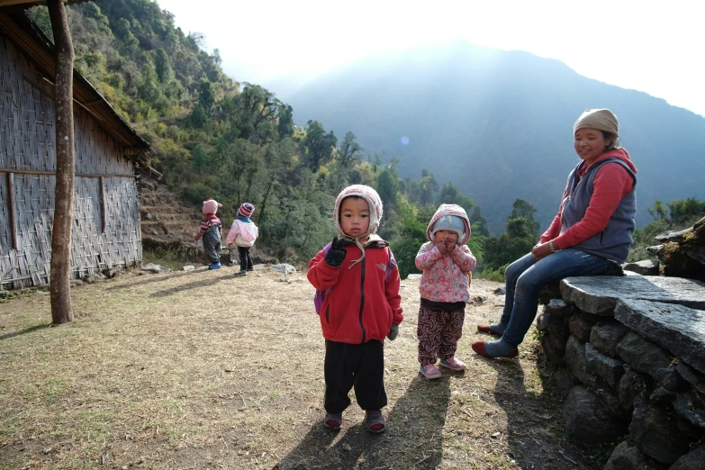 three children on a mountain top with mountains behind them