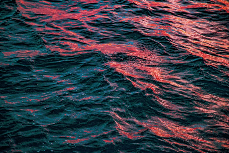 a large body of water with red and blue waves