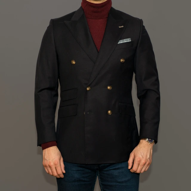 a male model wearing a black pea coat and red sweater