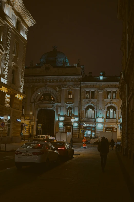 people walk along a walkway outside a big building