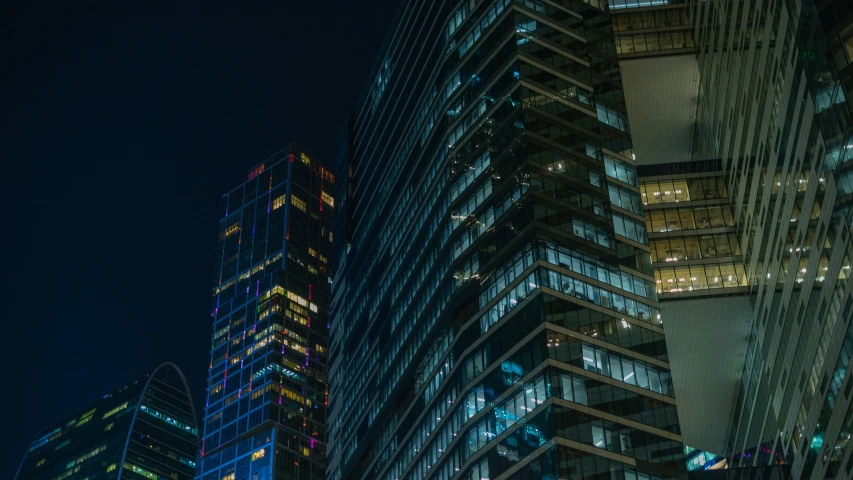 a bunch of tall buildings are lit up at night