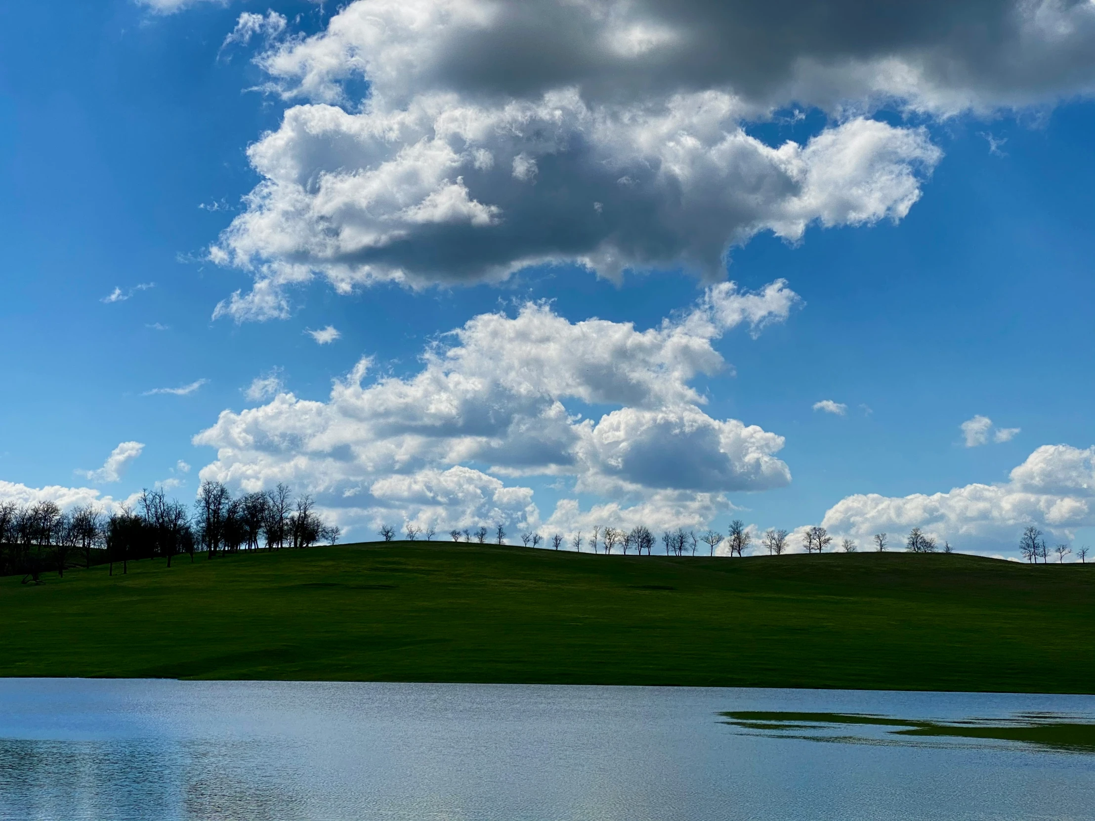 the sky is full of clouds above some water