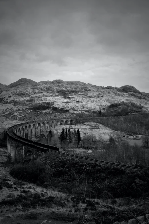 an old and abandoned train crossing through the hills