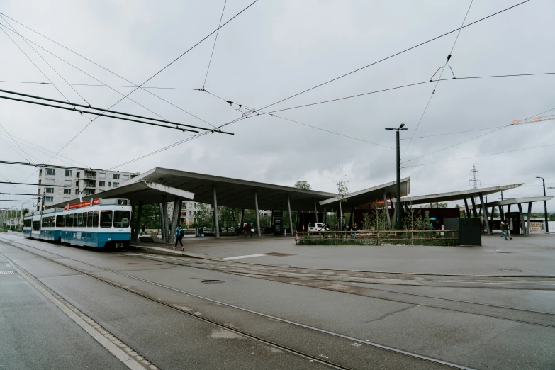 an electric train stopped in front of a depot