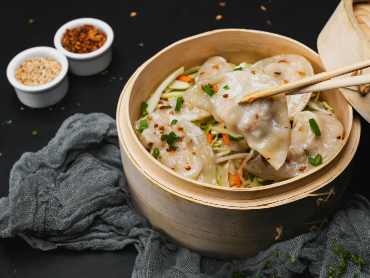 two bowls with food sitting on a black surface