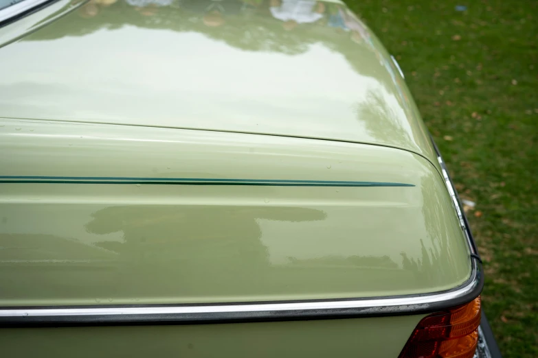 a light green car that has the door handles down