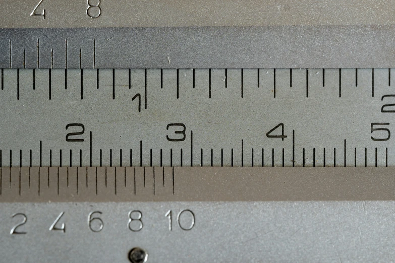 a metal ruler is holding some silver objects