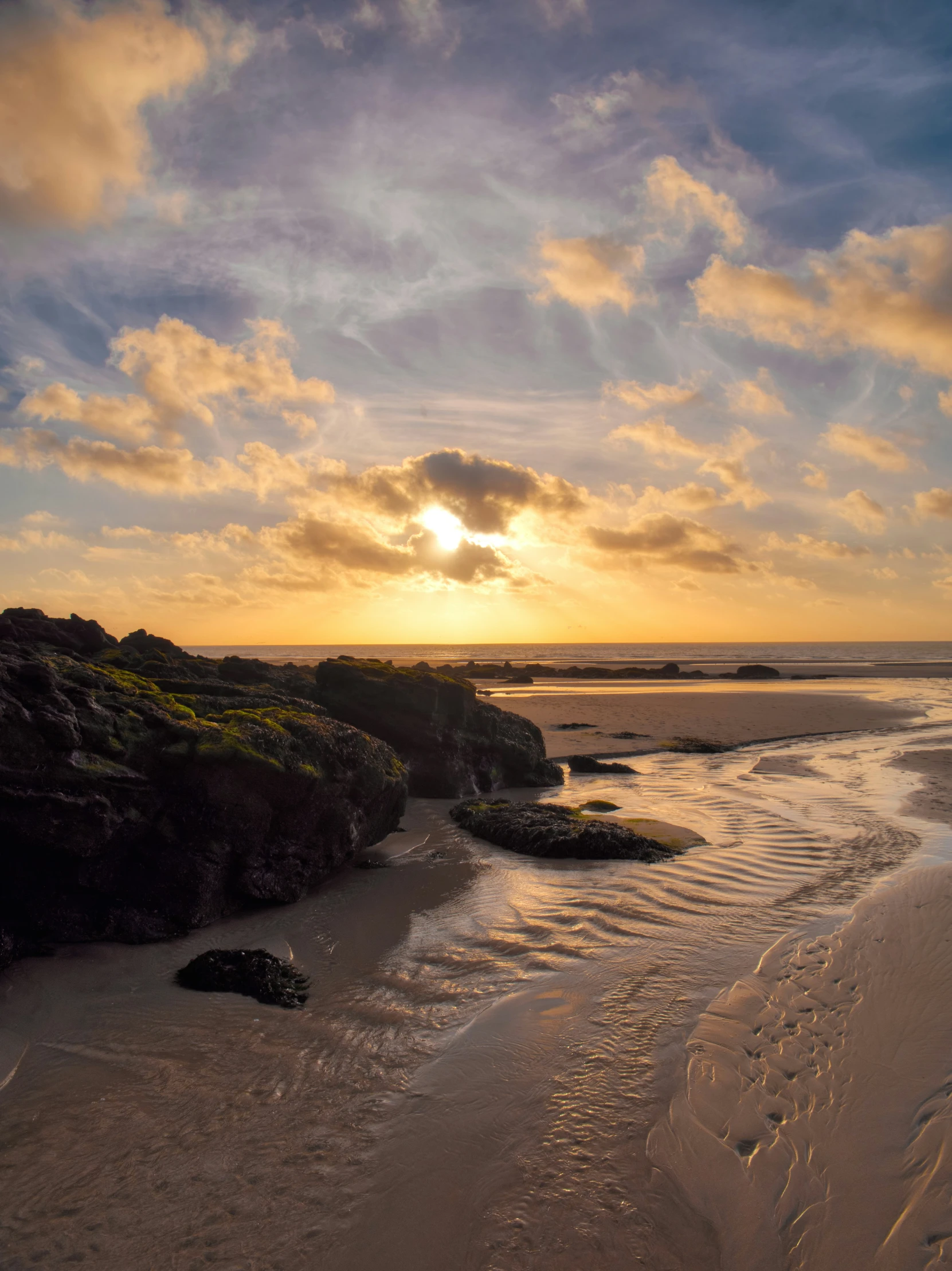 the sun rises over the shore while a couple of people ride on surfboards