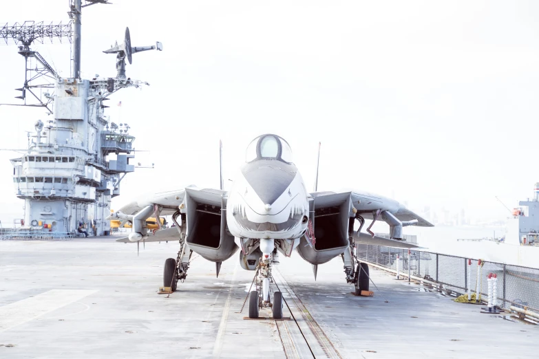 a jet fighter parked on the deck of an aircraft carrier