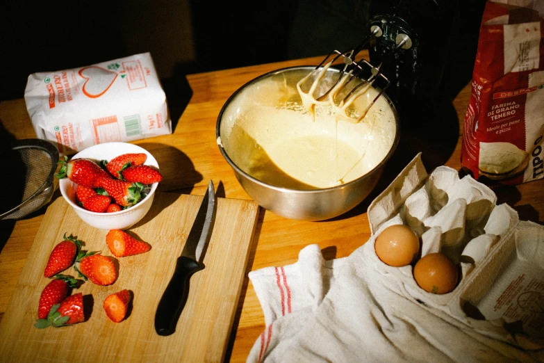 ingredients to make strawberry pancake laid out on  board