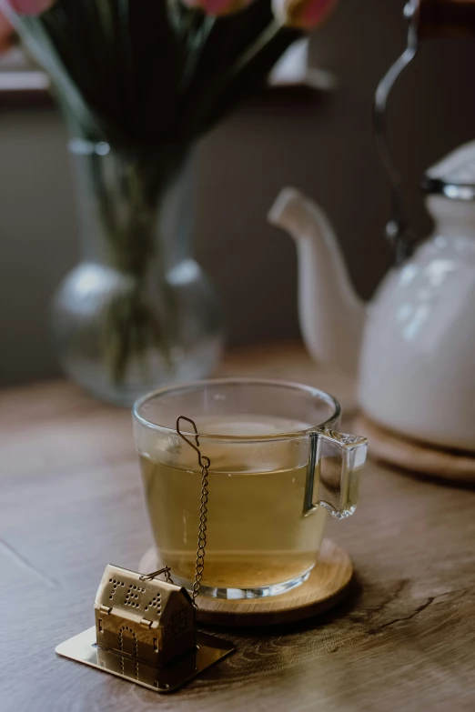 a glass cup on a wooden plate with an object inside