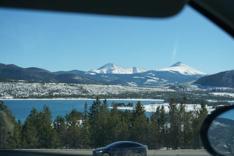 the view of snow capped mountains from inside a car