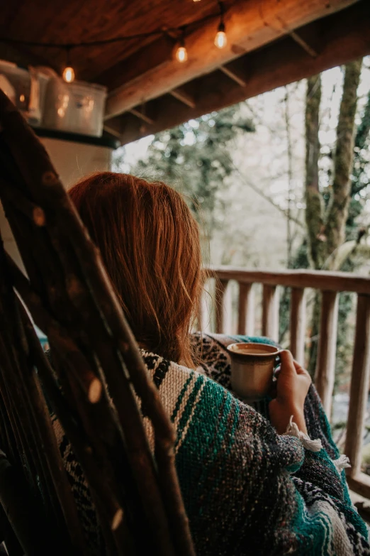 the back of a woman sitting on a porch