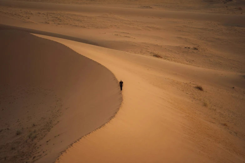 an area with several dunes with a few small people walking on it