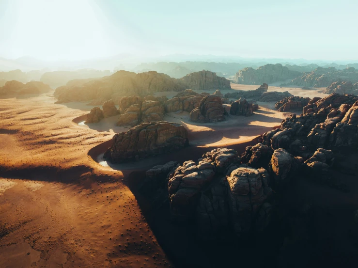 some rocks and dirt in the desert with sunlight coming from behind