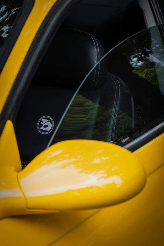 a car door with a yellow door, mirror and black passenger side view mirror