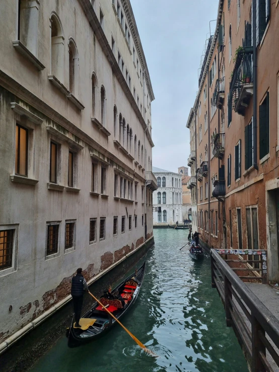 two gondola boats sailing through a narrow waterway