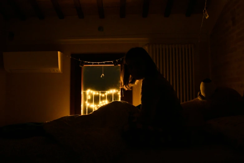 a person sitting in bed looking at the light on the wall