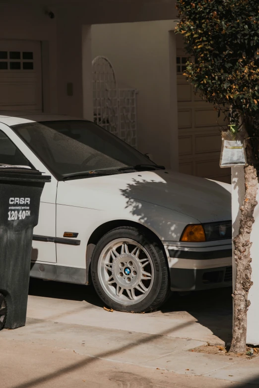 the bmw s - type sedan is parked in front of a house