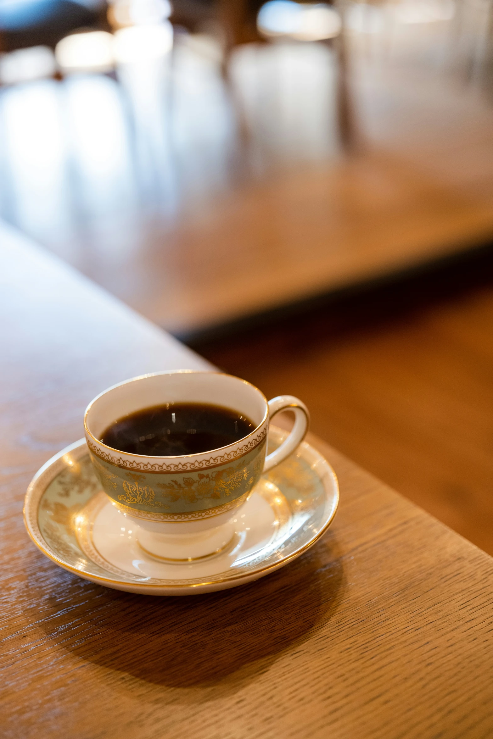 a small cup of coffee sitting on a wooden table