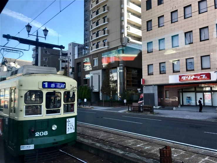 a passenger trolley drives down the tracks in front of a building