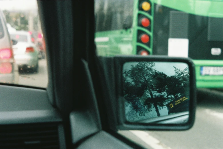 there is a bus that is in the rear view mirror