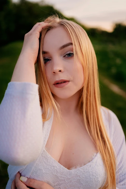 a very young blond woman is posing for the camera