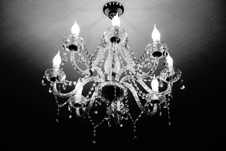 black and white po of a chandelier with five lit candles